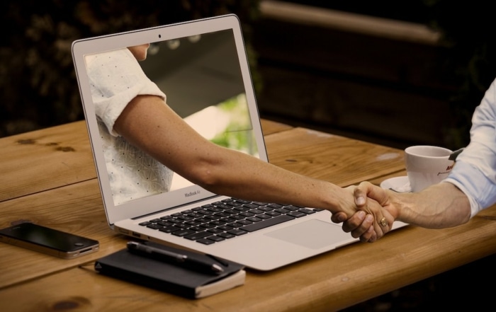 BGM Laptop Handshake zwei Männer Schreibtisch