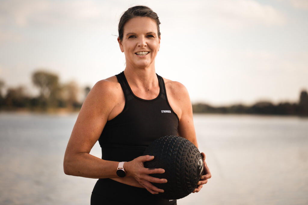 Mona von mova mit Sportausstattung vorm Wasser.