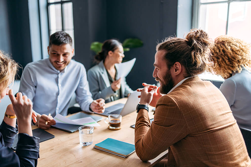 Personen sitzen an einem Tisch Kollegen sitzen bei einem Meeting an einem Tisch