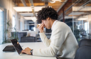 Person sitzt vor einem Laptop