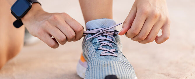 Person bindet Laufschuh zu