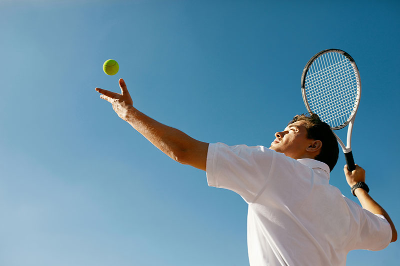Ein Mann macht den Aufschlag beim Tennis