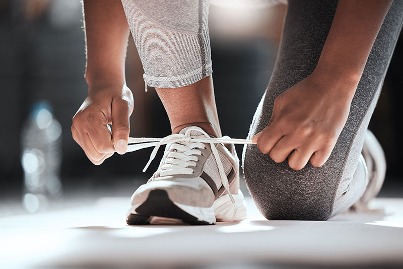Eine Person schnürt sich die Schuhe zum Laufen