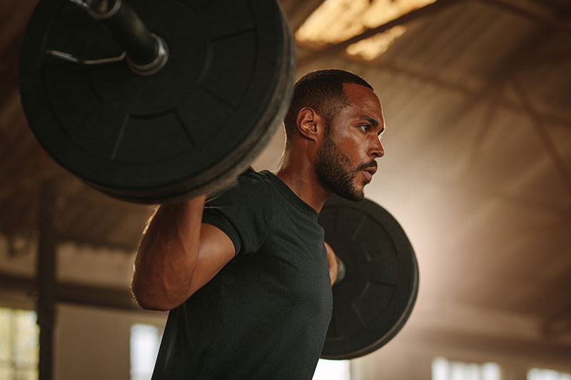 Ein Mann im Fitnessstudio stemmt Gewichte