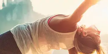 Eine Frau macht draußen Hatha Yoga