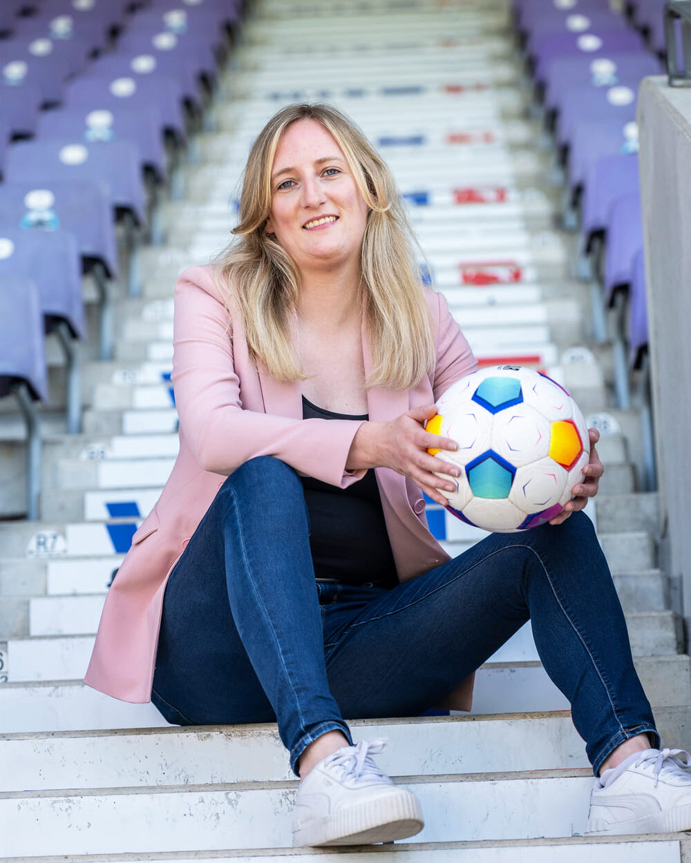 erfolgsgeschichte-vfl-3 Marina Busch, Referentin Geschäftsführung und Personal beim VfL Osnabrück sitzt im Stadion.