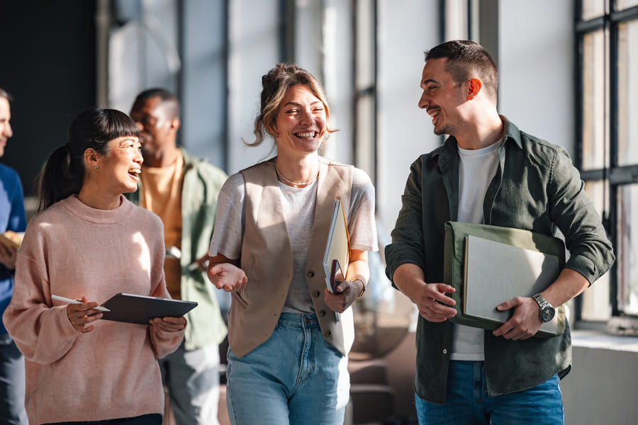 Eine Gruppe von Mitarbeitenden gehen zusammen durch das Büro.